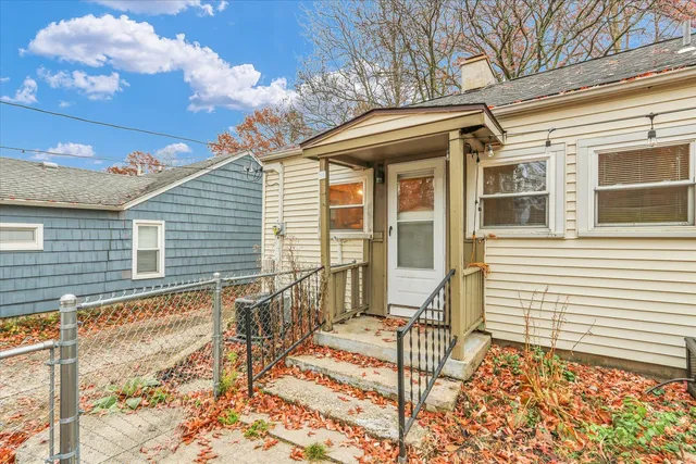 a view of a house with a small yard and wooden floor and fence