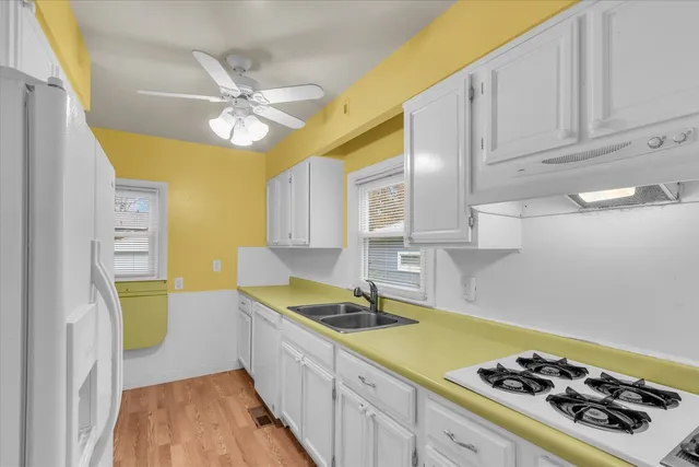 a kitchen with a sink a stove and cabinets
