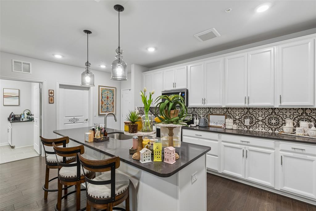 651 Watters Road, Unit 7204 Allen, TX 75013 - Photo 13 of 40 a kitchen with center island table and chairs in it