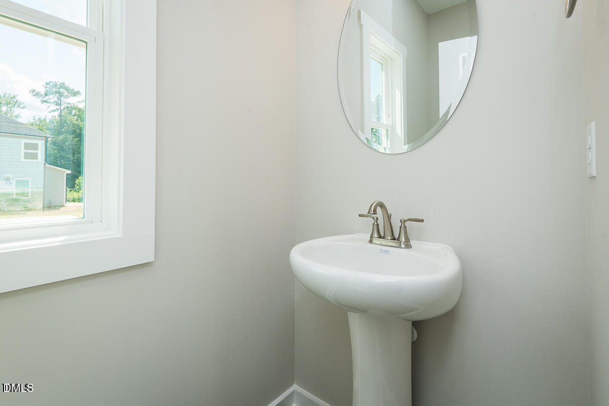 1016 Pinnix Loop Burlington, NC 27217 - Photo 22 of 22 a bathroom with a sink a mirror and a window