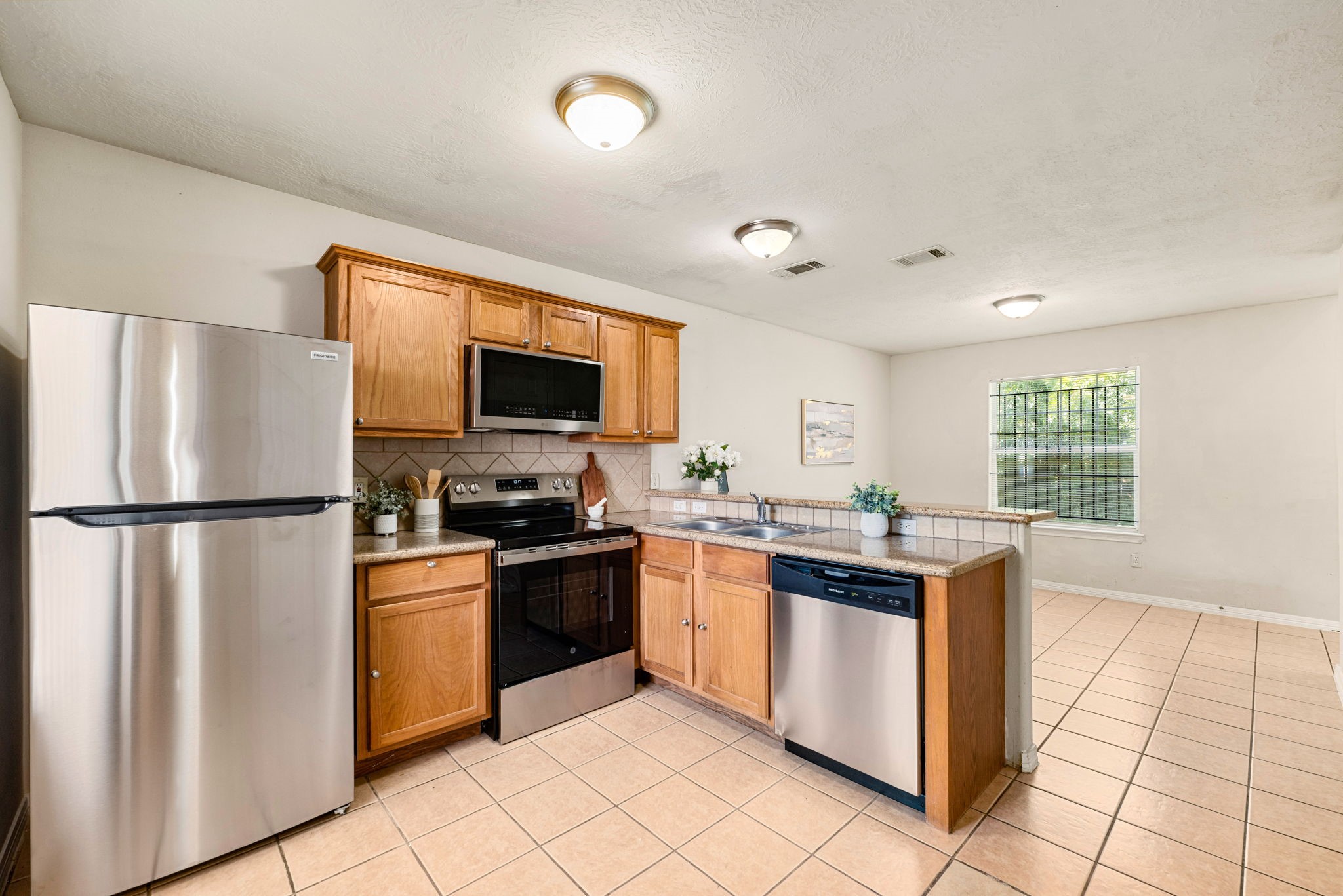 6418 England Street Houston, TX 77021 - Photo 6 of 29 a kitchen with stainless steel appliances granite countertop a stove top oven a sink and a refrigerator