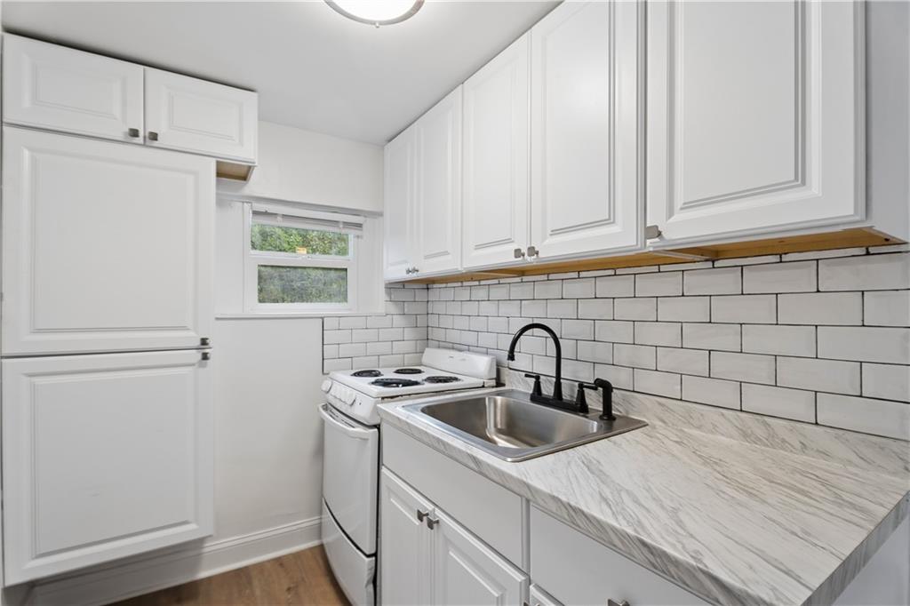 2526 Semmes Street Atlanta, GA 30344 - Photo 6 of 29 a kitchen with stainless steel appliances a sink a refrigerator and cabinets