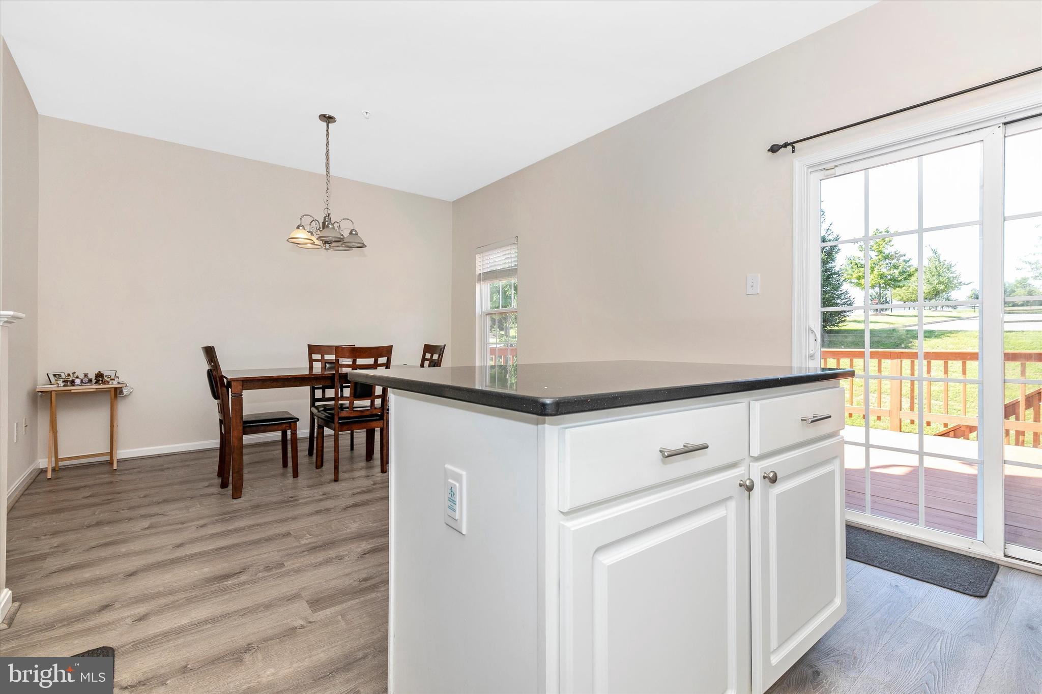 1742 Trestle Street Mount Airy, MD 21771 - Photo 22 of 58 a kitchen with stainless steel appliances kitchen island hardwood floor sink stove dining table and chairs