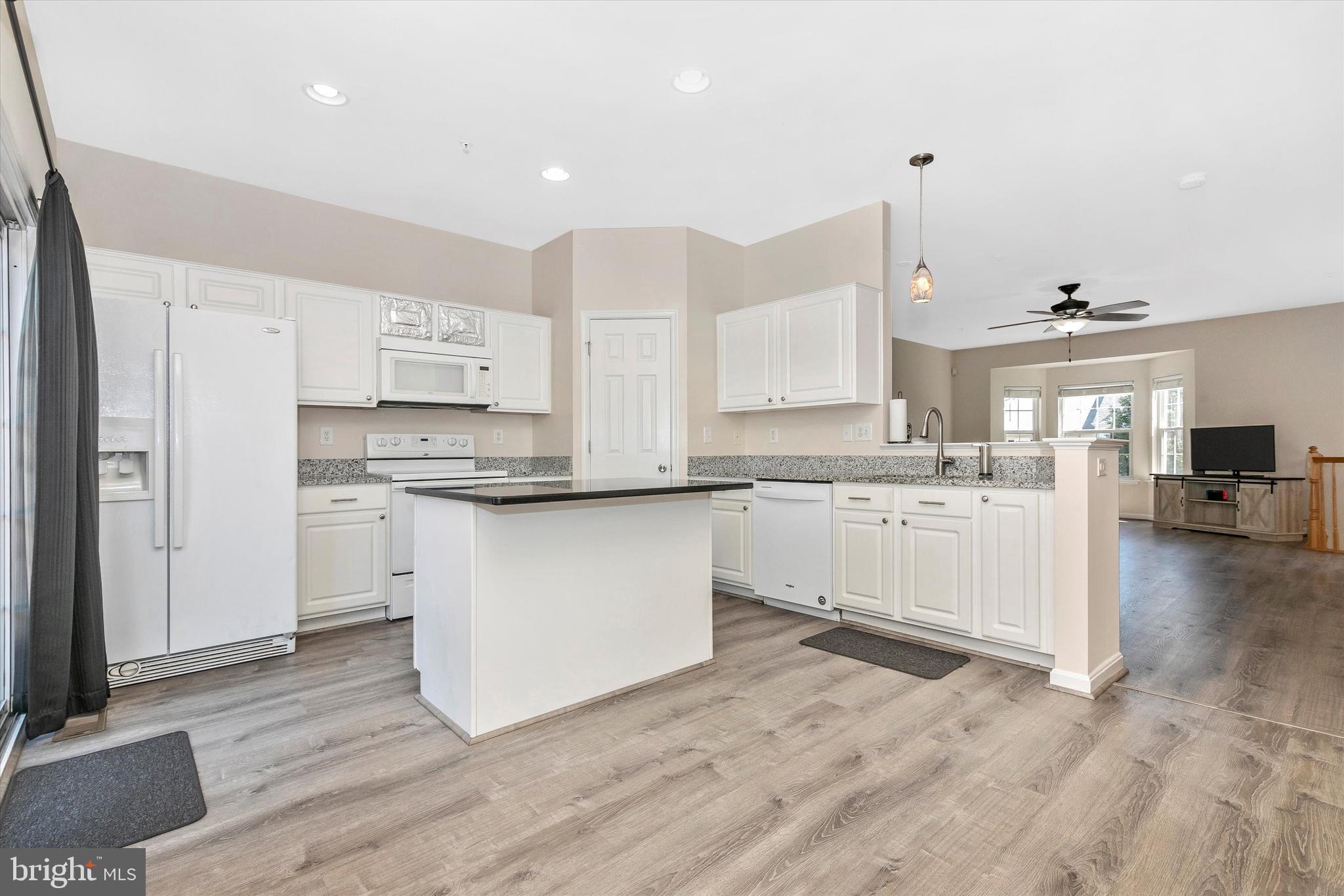 1742 Trestle Street Mount Airy, MD 21771 - Photo 23 of 58 a kitchen with stainless steel appliances granite countertop a stove a sink and white cabinets with wooden floor