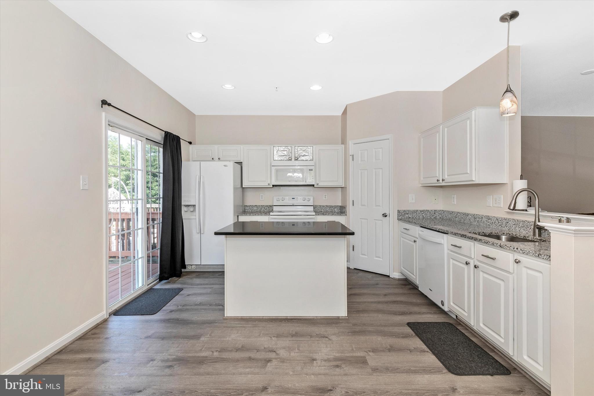 1742 Trestle Street Mount Airy, MD 21771 - Photo 24 of 58 a kitchen with granite countertop wooden floors and white cabinets