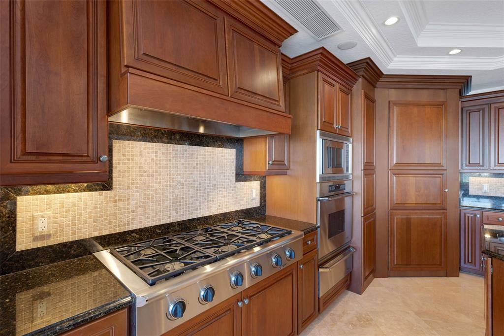 464 Golden Gate Point, Unit 403 Sarasota, FL 34236 - Photo 34 of 95 a kitchen with stainless steel appliances granite countertop a refrigerator and a stove top oven