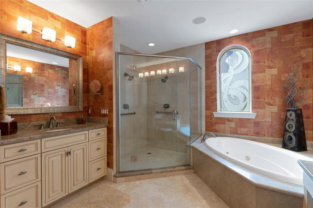 464 Golden Gate Point, Unit 403 Sarasota, FL 34236 - Photo 56 of 95 a bathroom with a granite countertop tub sink a mirror a shower and vanity