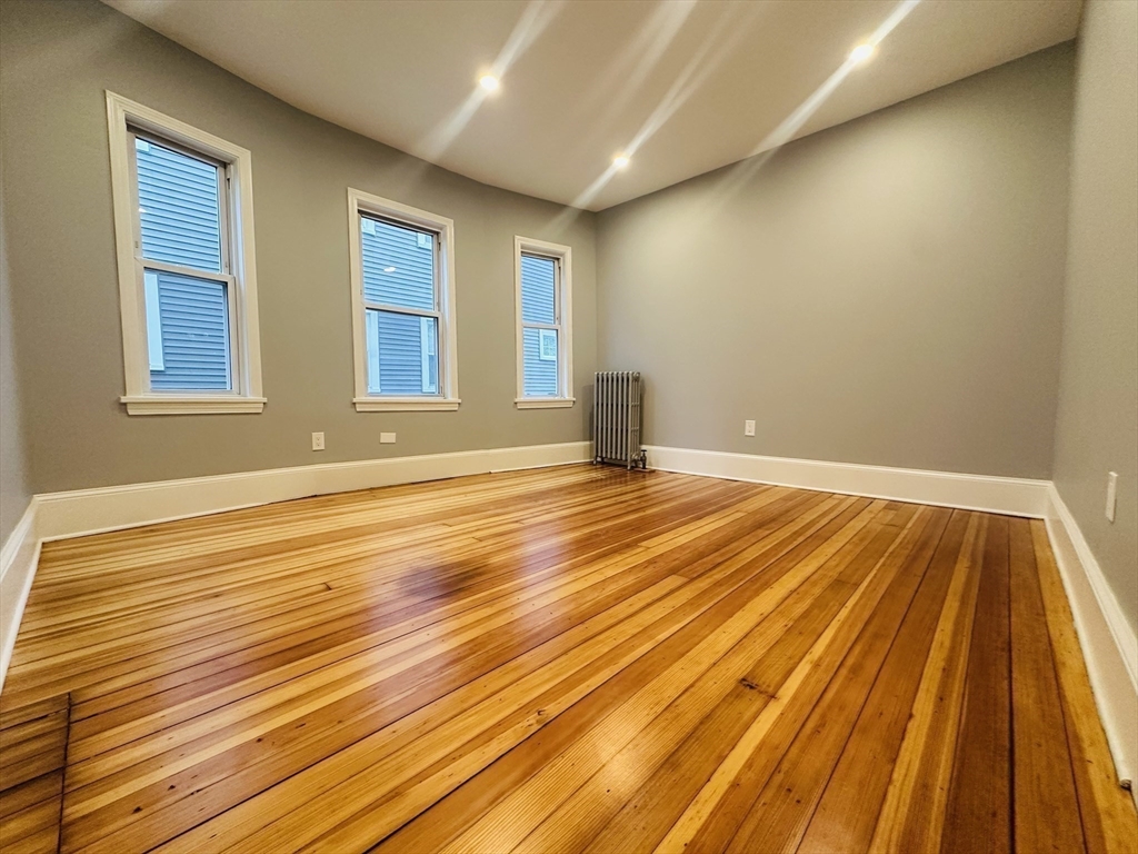 28 Melbourne Street, Unit 2 Boston, MA 02124 - Photo 15 of 27 a view of an empty room with wooden floor and a window