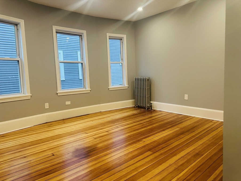 28 Melbourne Street, Unit 2 Boston, MA 02124 - Photo 16 of 27 a view of an empty room with wooden floor and a window