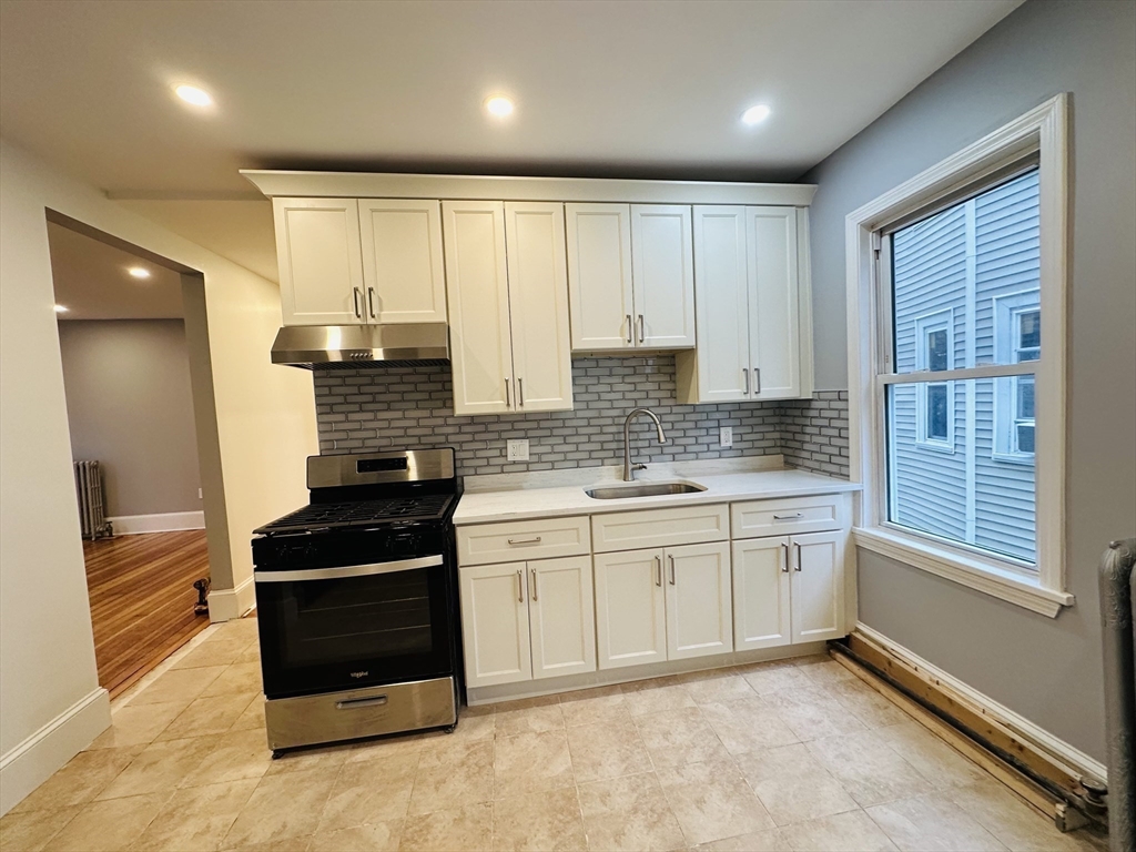 28 Melbourne Street, Unit 2 Boston, MA 02124 - Photo 6 of 27 a kitchen with granite countertop white cabinets and appliances