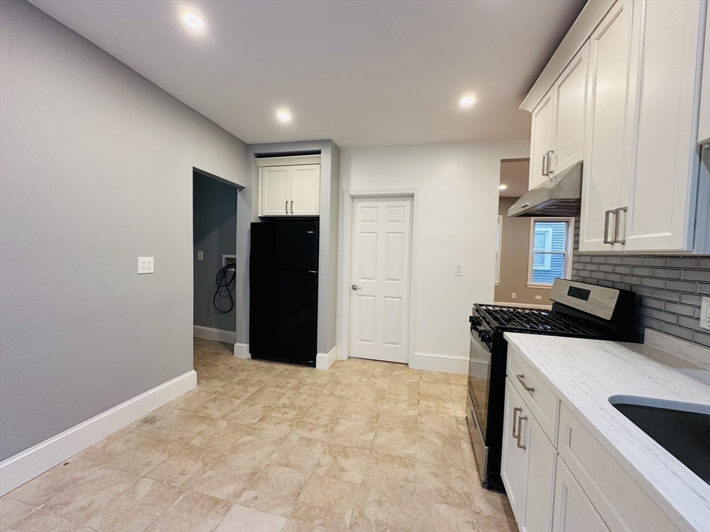 28 Melbourne Street, Unit 2 Boston, MA 02124 - Photo 8 of 27 a kitchen with a refrigerator and a stove top oven