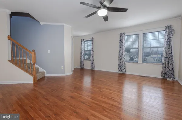 an empty room with wooden floor and entryway