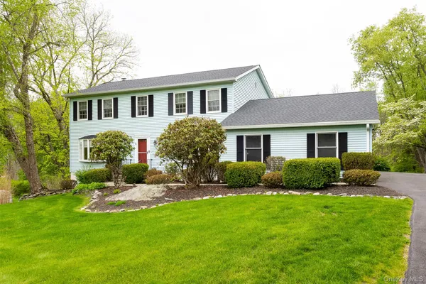 a front view of a house with a yard and outdoor seating