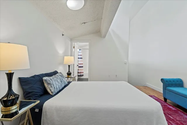 a bedroom with a bed and lamp