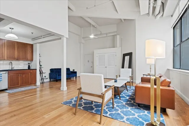 a living room with furniture a wooden floor and a sink