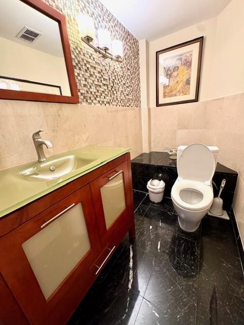 1540 Northeast Quayside Terrace, Unit D1 Miami, FL 33138 - Photo 10 of 45 a bathroom with a toilet a sink and mirror