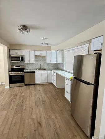 a kitchen with a refrigerator a microwave and cabinets