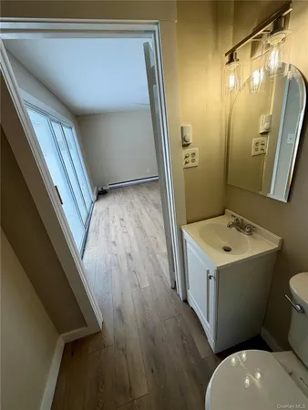 a bathroom with a sink and mirror with toilet
