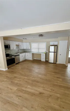 a view of a refrigerator and wooden floor