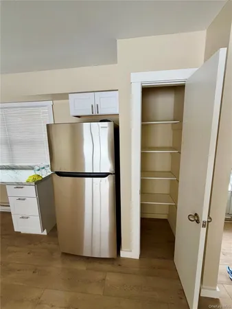 a kitchen with stainless steel appliances granite countertop a refrigerator sink and white cabinets