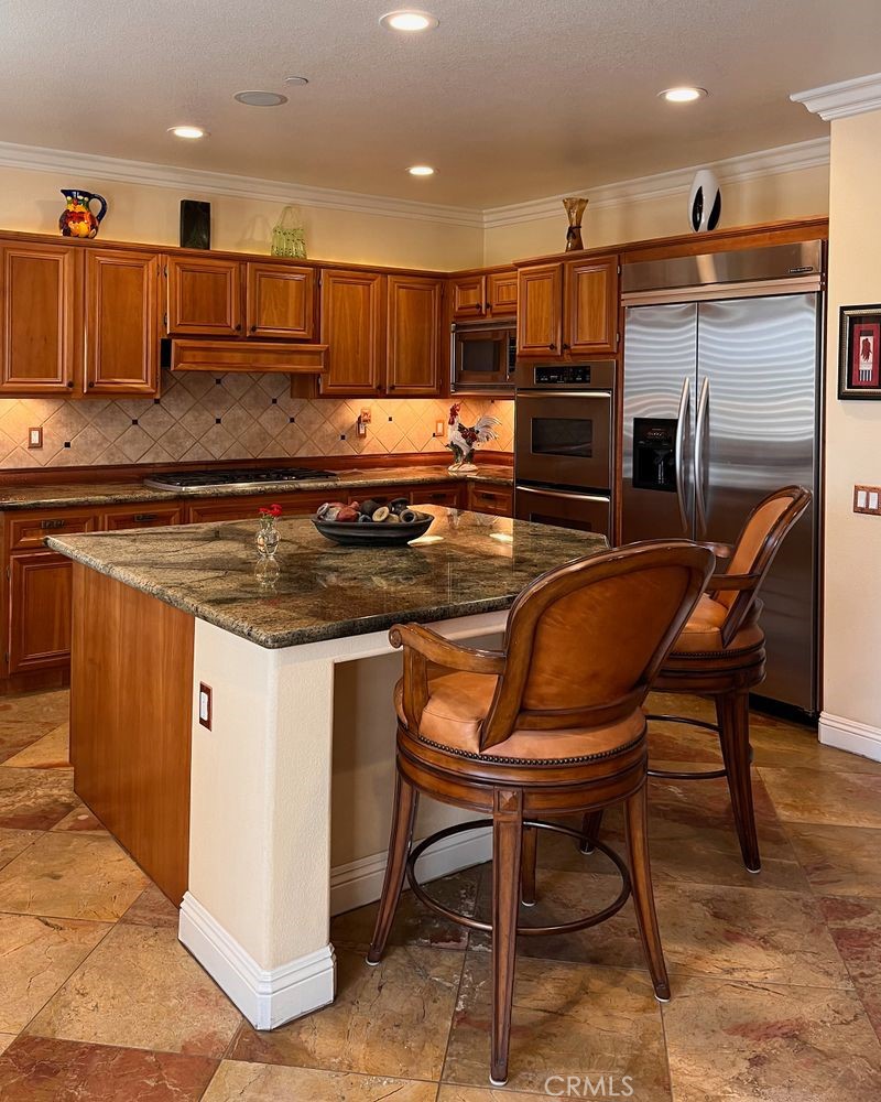 27 Mountain Laurel Way Azusa, CA 91702 - Photo 16 of 39 a kitchen with kitchen island granite countertop wooden cabinets and a refrigerator
