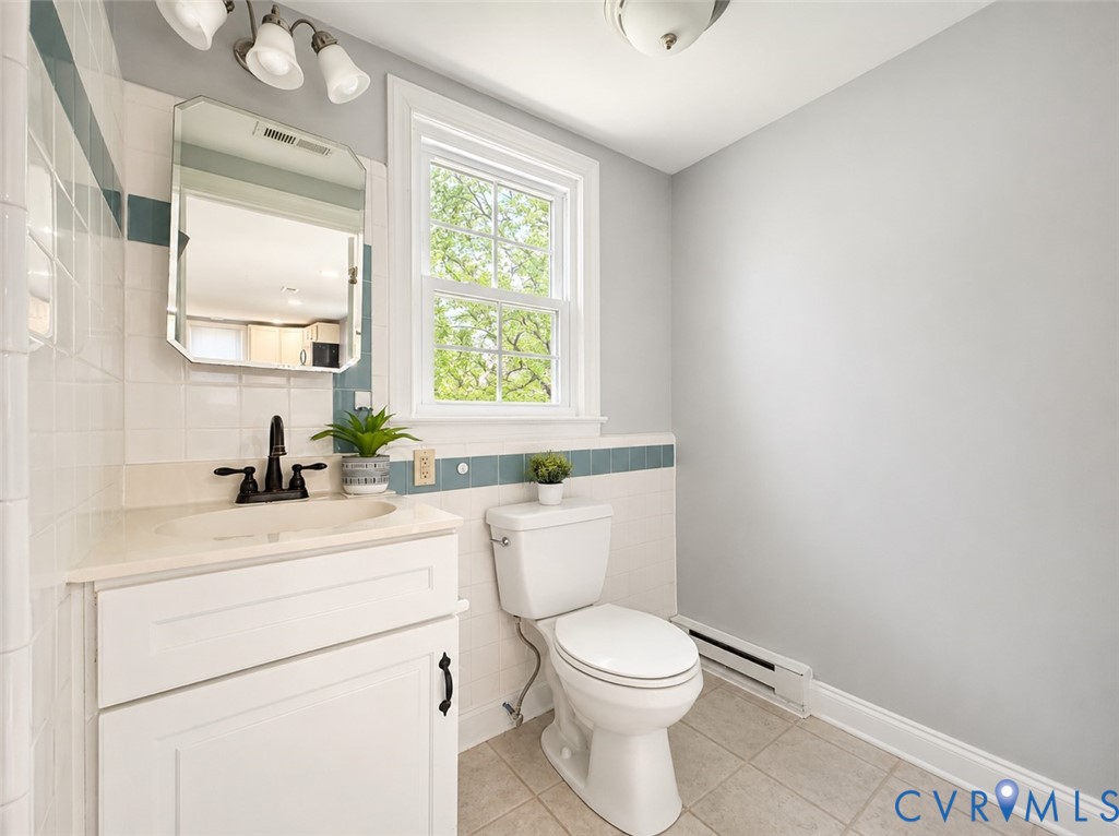110 Locust Grove Cartersville, VA 23027 - Photo 22 of 26 a bathroom with a toilet sink a mirror and a window