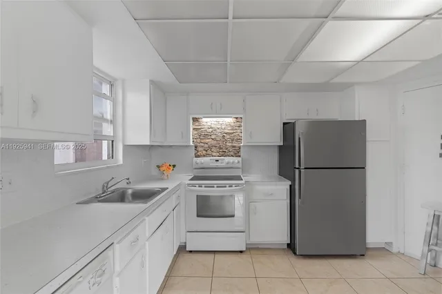 a kitchen with a sink a refrigerator and cabinets