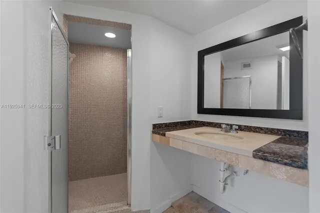 a bathroom with a granite countertop sink and a mirror