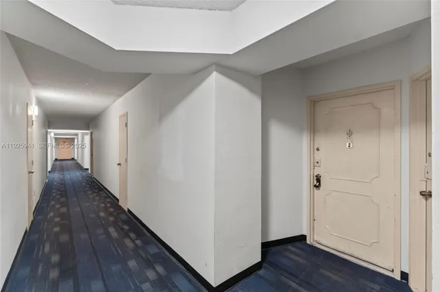 a view of a hallway with wooden floor and closet