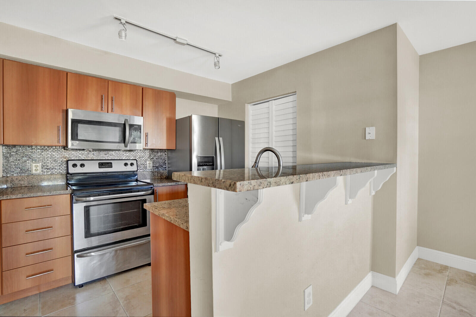 1215 Crystal Way, Unit N Delray Beach, FL 33444 - Photo 11 of 29 a kitchen with stainless steel appliances granite countertop a refrigerator and a stove top oven