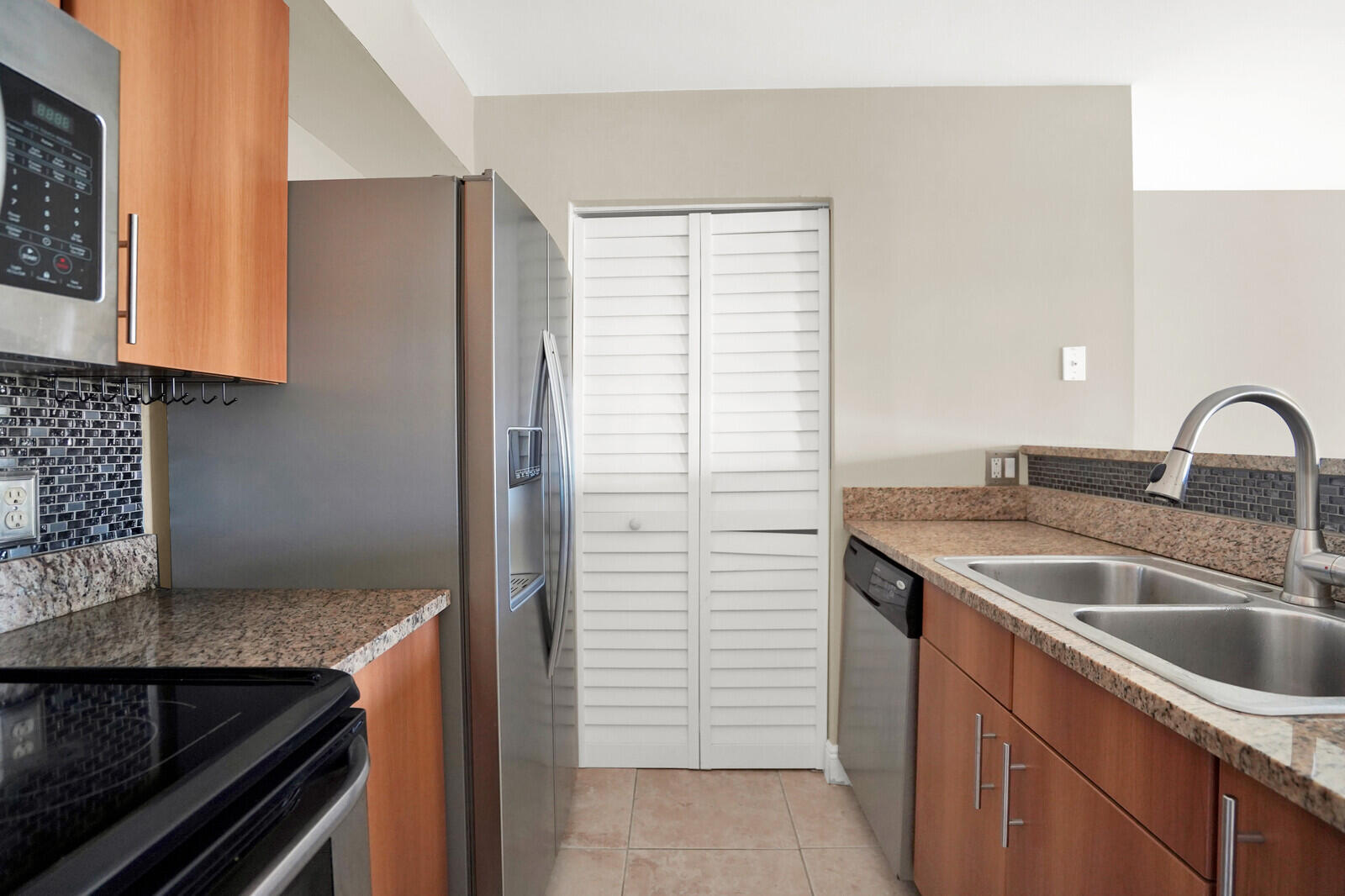1215 Crystal Way, Unit N Delray Beach, FL 33444 - Photo 13 of 29 a kitchen with a sink and a stove top oven