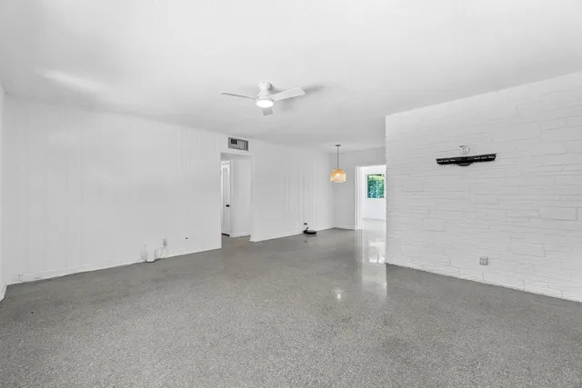 an empty room with an entryway and fan