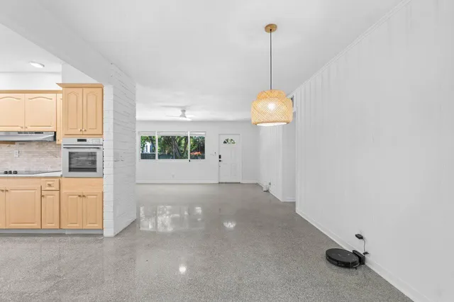 a view of an empty room with window and cabinet