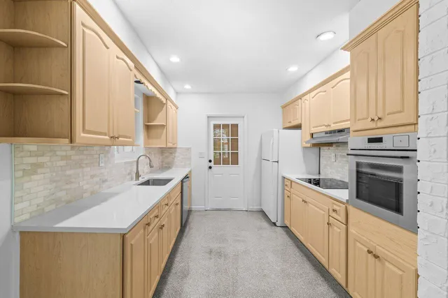 a kitchen with granite countertop white cabinets and white appliances