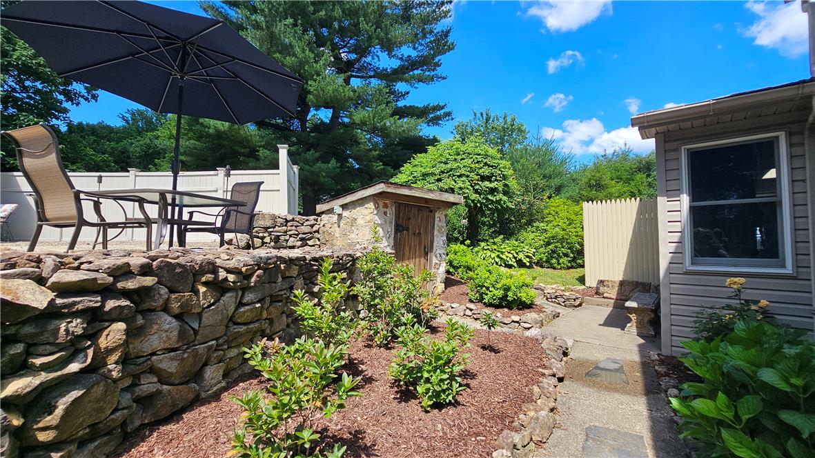 585 Buttermilk Road Hellertown, PA 18055 - Photo 46 of 82 An inviting stone patio with a dining set and umbrella offers a pleasant outdoor retreat.