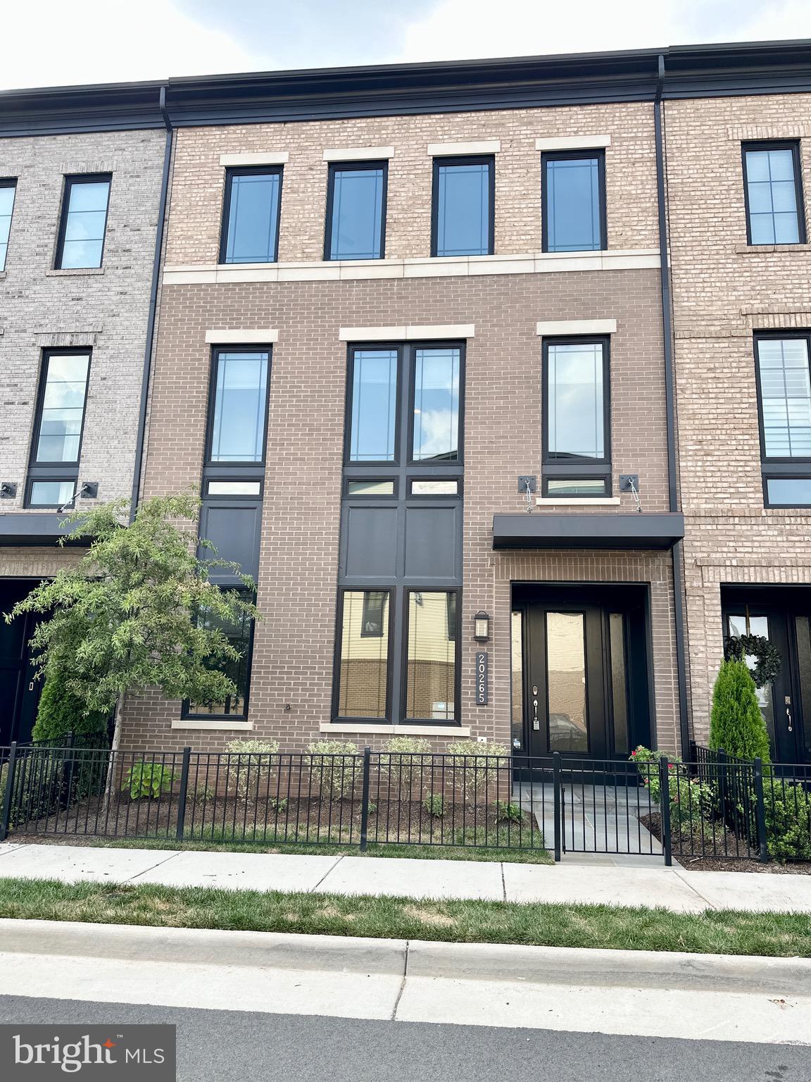 20265 Oak Bluff Drive Ashburn, VA 20147 - Photo 1 of 42 a view of a brick building next to a yard