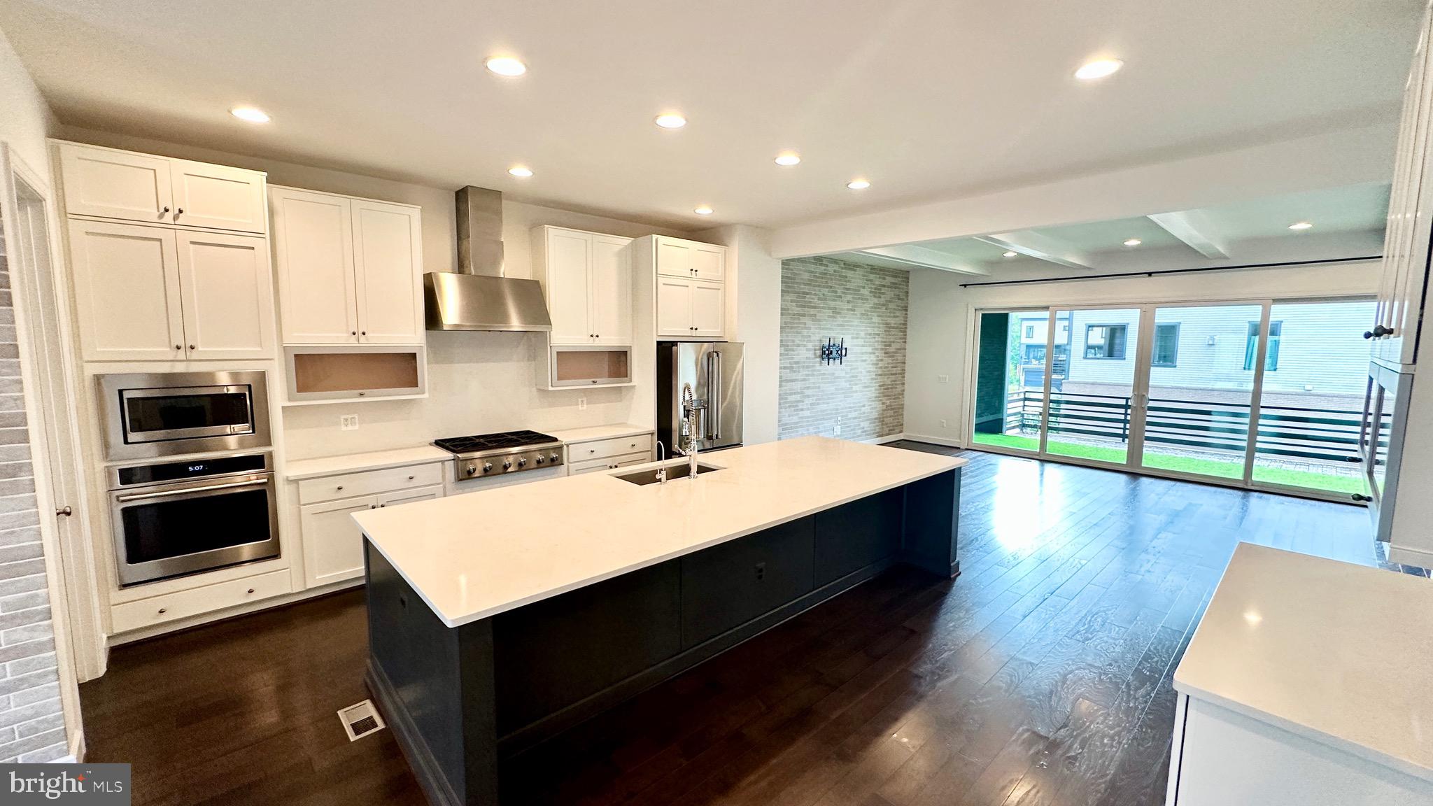 20265 Oak Bluff Drive Ashburn, VA 20147 - Photo 11 of 42 a large kitchen with stainless steel appliances a large counter top a stove and a refrigerator