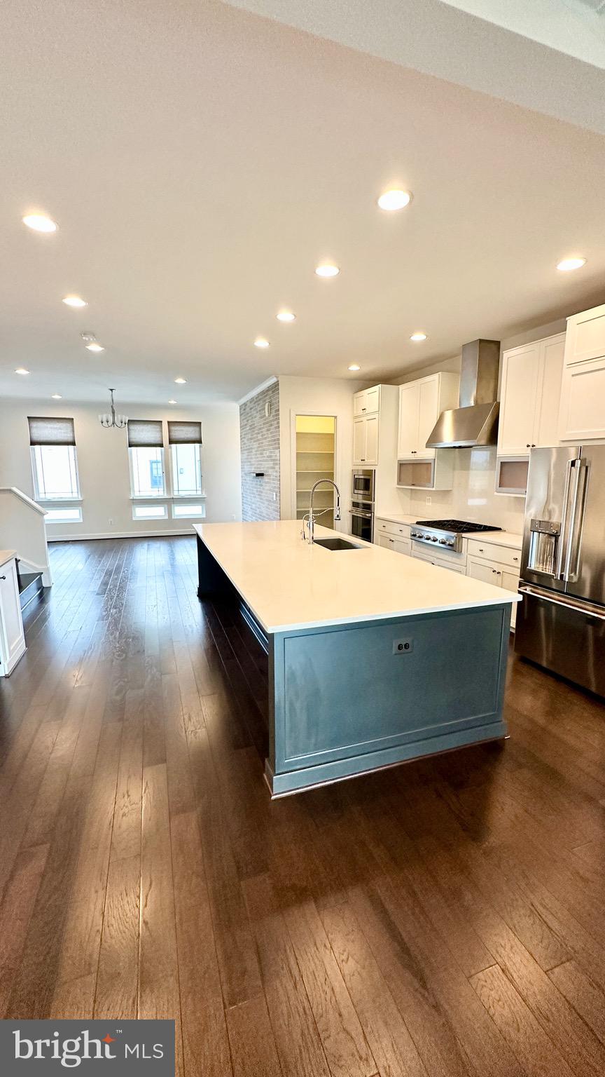 20265 Oak Bluff Drive Ashburn, VA 20147 - Photo 15 of 42 a large kitchen with wooden floors and stainless steel appliances