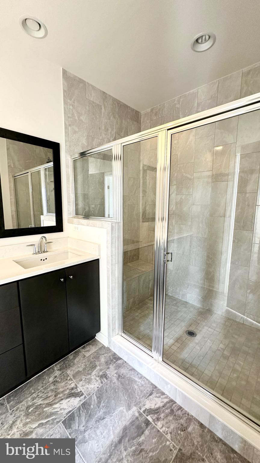 20265 Oak Bluff Drive Ashburn, VA 20147 - Photo 27 of 42 a bathroom with a shower sink and mirror