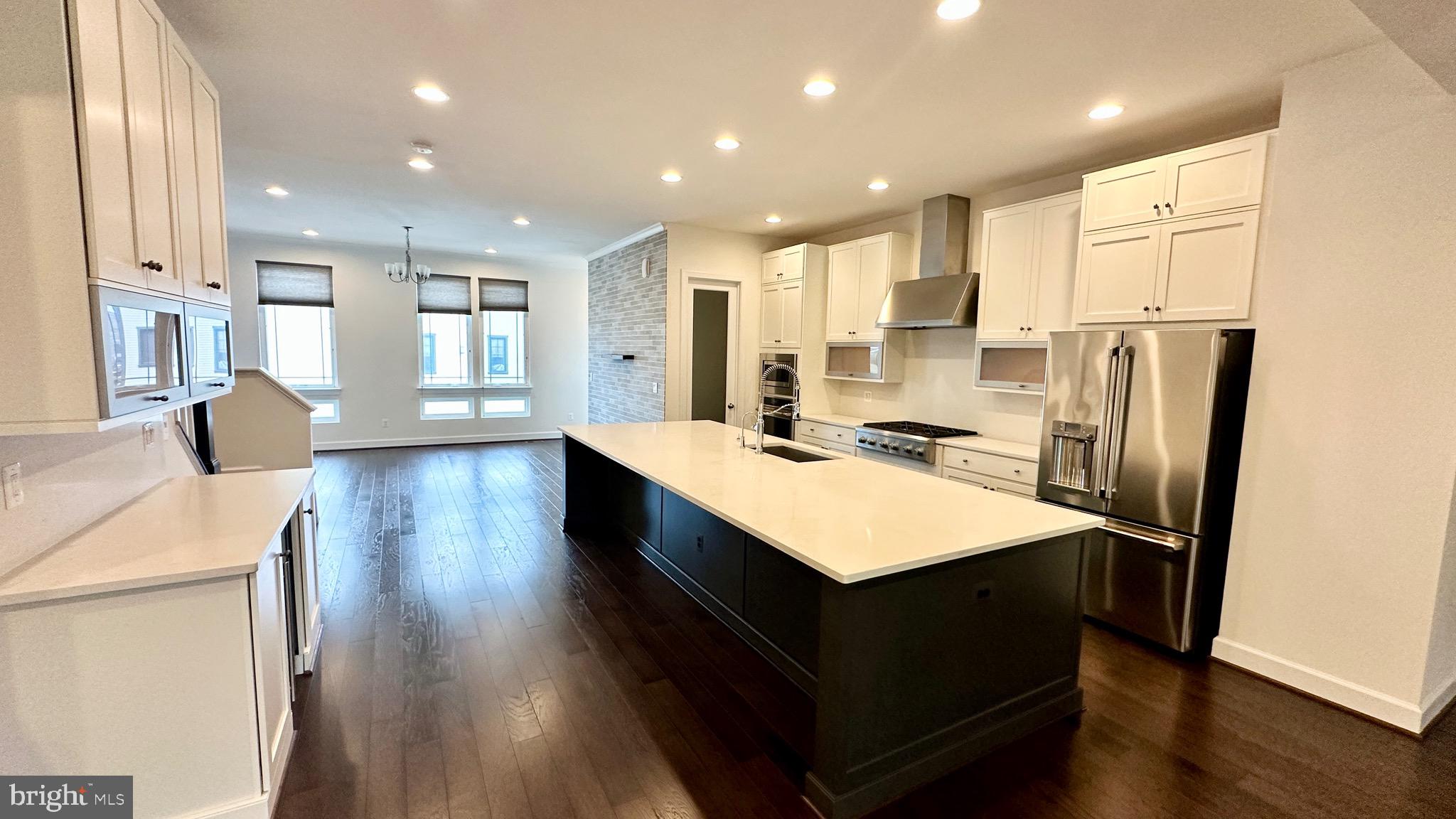 20265 Oak Bluff Drive Ashburn, VA 20147 - Photo 9 of 42 a large kitchen with stainless steel appliances a refrigerator a sink dishwasher a stove and white cabinets with wooden floor