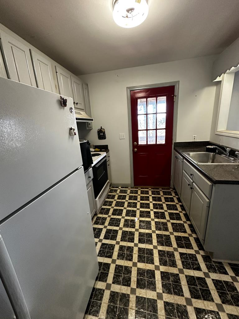 1966 Highway 142 Covington, GA 30014 - Photo 13 of 96 a kitchen with a black white checkered floor and a stove