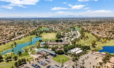 an aerial view of a city with lots of residential buildings ocean and mountain view in back
