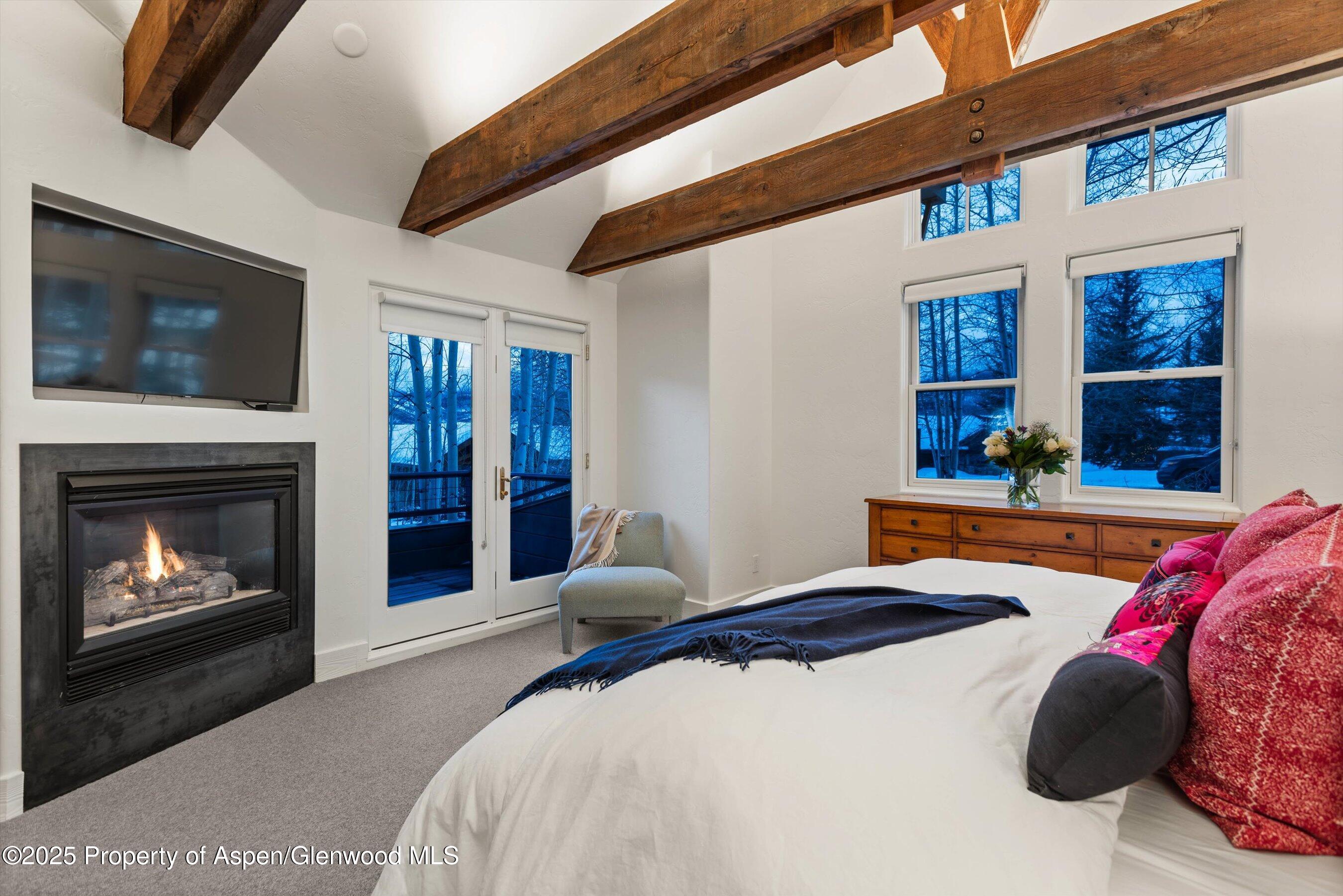 124 Trail Rider Lane Snowmass Village, CO 81615 - Photo 15 of 39 a bedroom with a bed and a fireplace