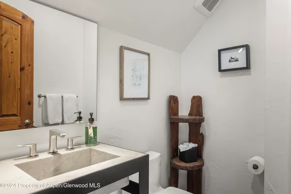 a bathroom with a sink a toilet and a mirror