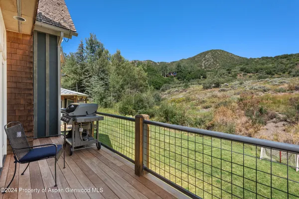 a view of a city from a balcony with chairs