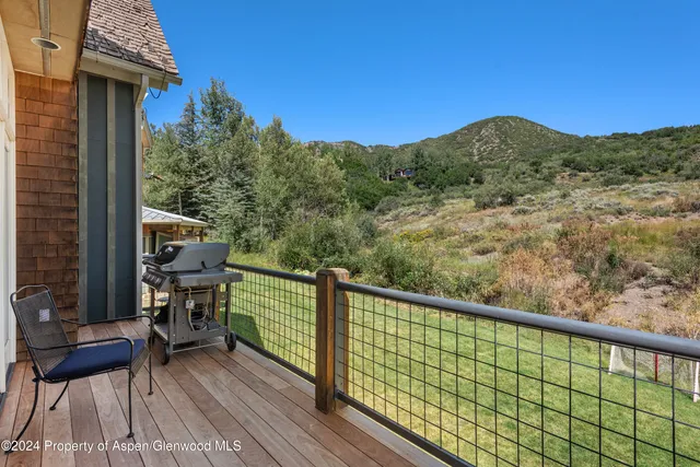 a view of a city from a balcony with chairs