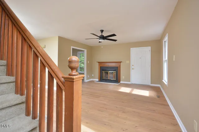 a view of an empty room with a fireplace and a window