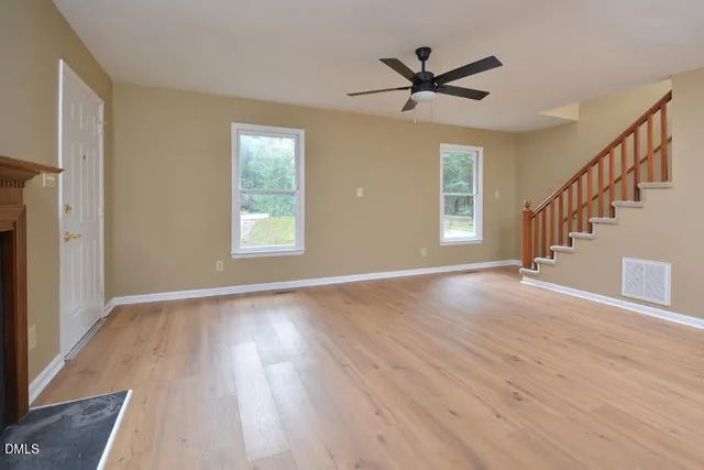 a view of a livingroom with wooden floor and a ceiling fan