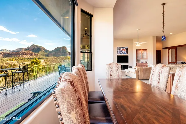 a dining room with stainless steel appliances granite countertop furniture and a large window