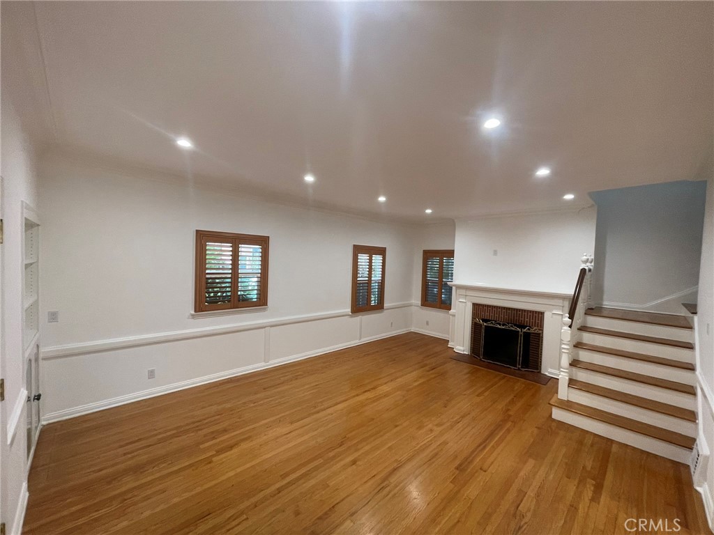 135 Canon Drive Beverly Hills, CA 90212 - Photo 11 of 42 an empty room with wooden floor fireplace and windows